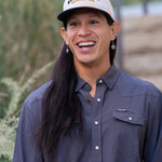 JP Guana wearing a Stockyard Supply Co hat with a faded navy blue performance pearl snap Stockyard Supply Co Shirt on.