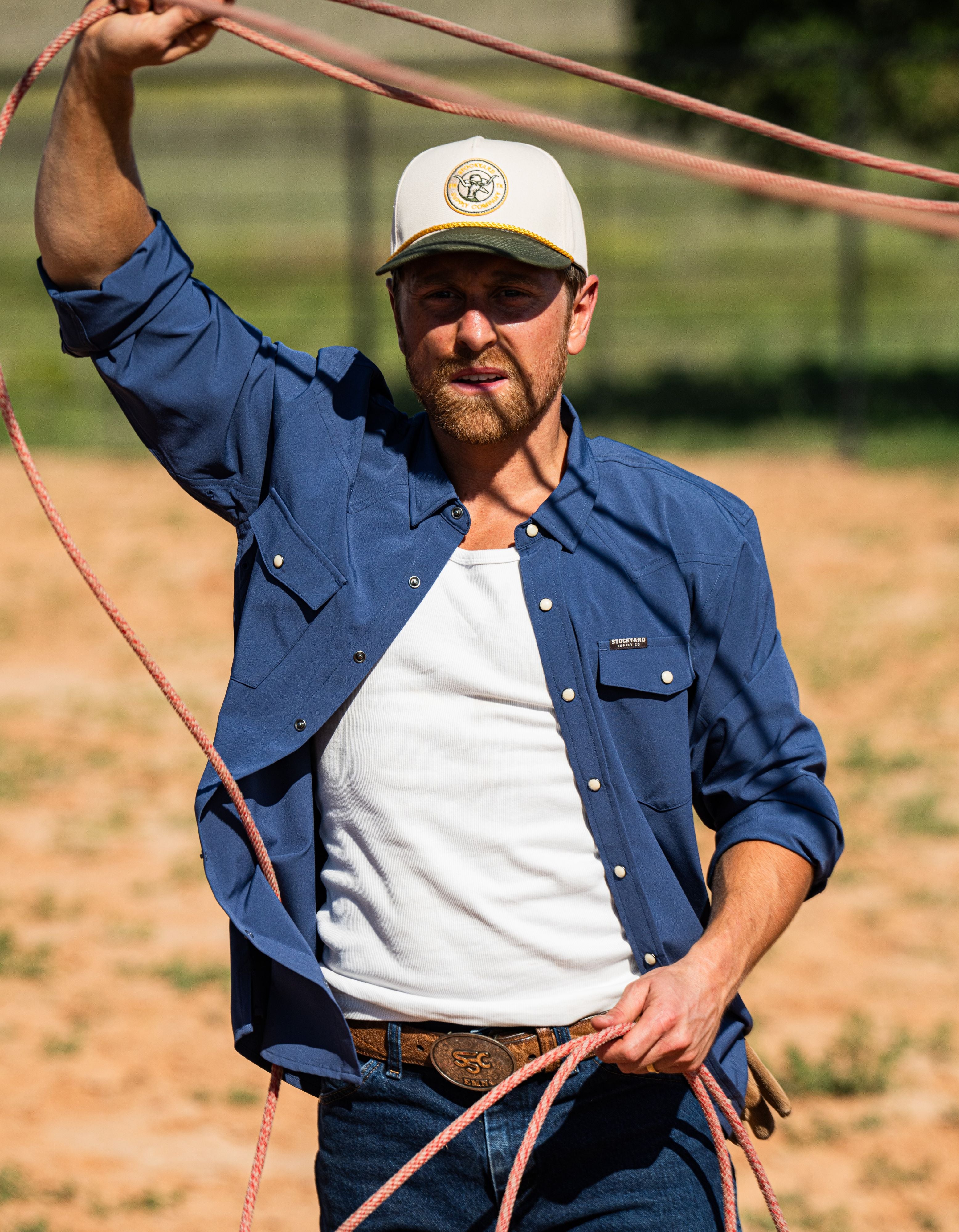 Eric Nelsen wearing Stockyard Supply Co Faded Navy Pearl Snap long sleeve button down roping