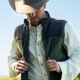 Eric Nelsen wearing Chocolate and Olive vest with cream pearl snap performance underneath with cowboy hat. 