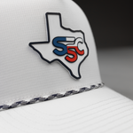 White cap with Texas-shaped logo featuring 'SSC' in blue and red on a blurred background